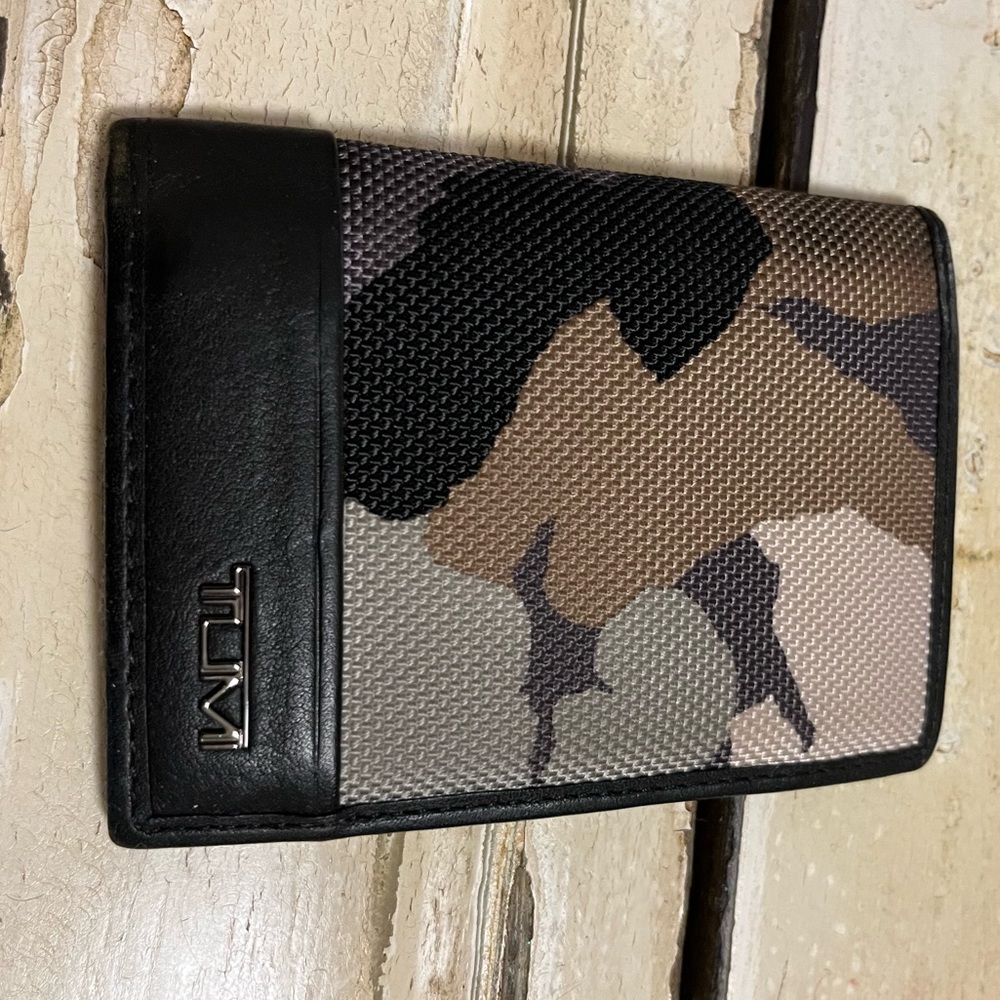 Tumi billfold in a brown / grey / tan / black print. Bifold with license window